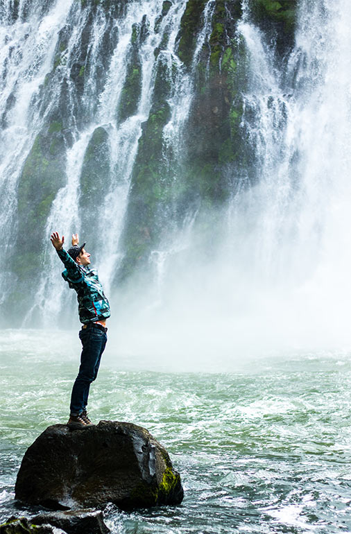 man rejoicing a waterfall QI